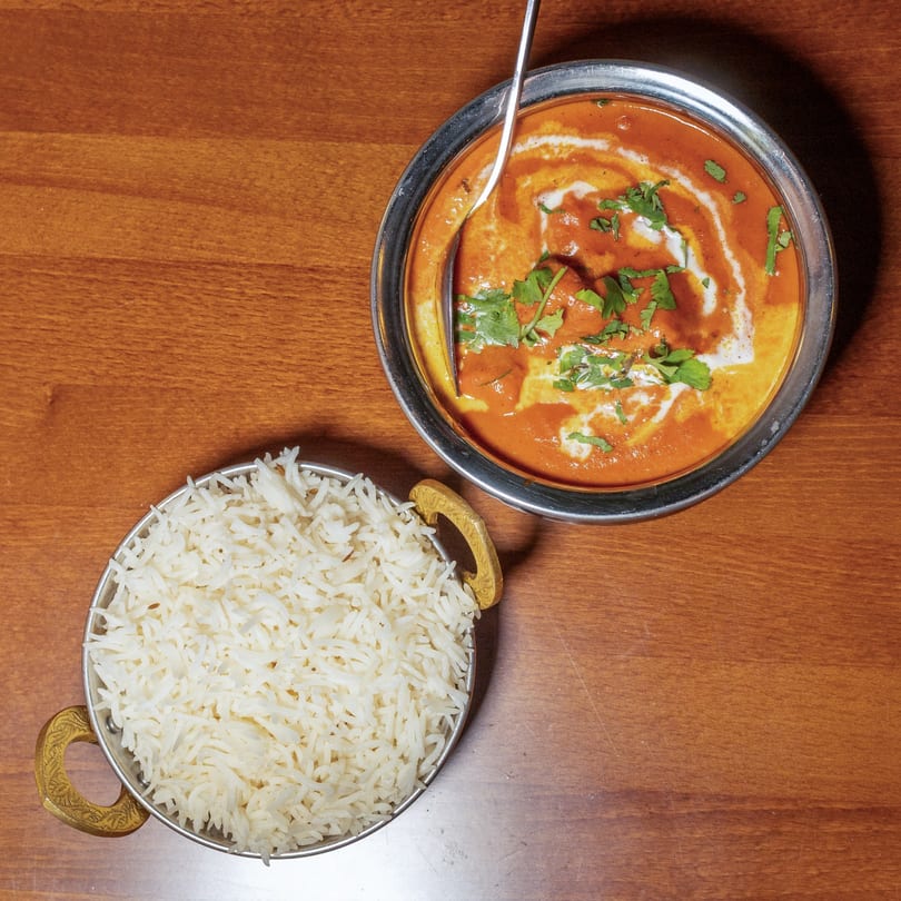 Manzil Fine Indian Dining's butter chicken with cream and cilantro, served with a side of basmati rice.
